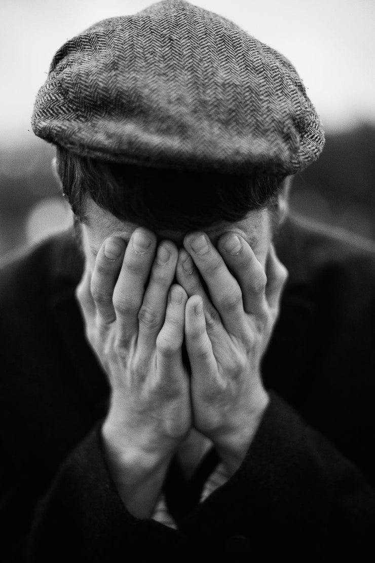 a man covering his face with his hands
