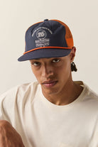 Unisex 76 Truck Stop Trucker Hat in the color Navy/Orange - Men's Front View